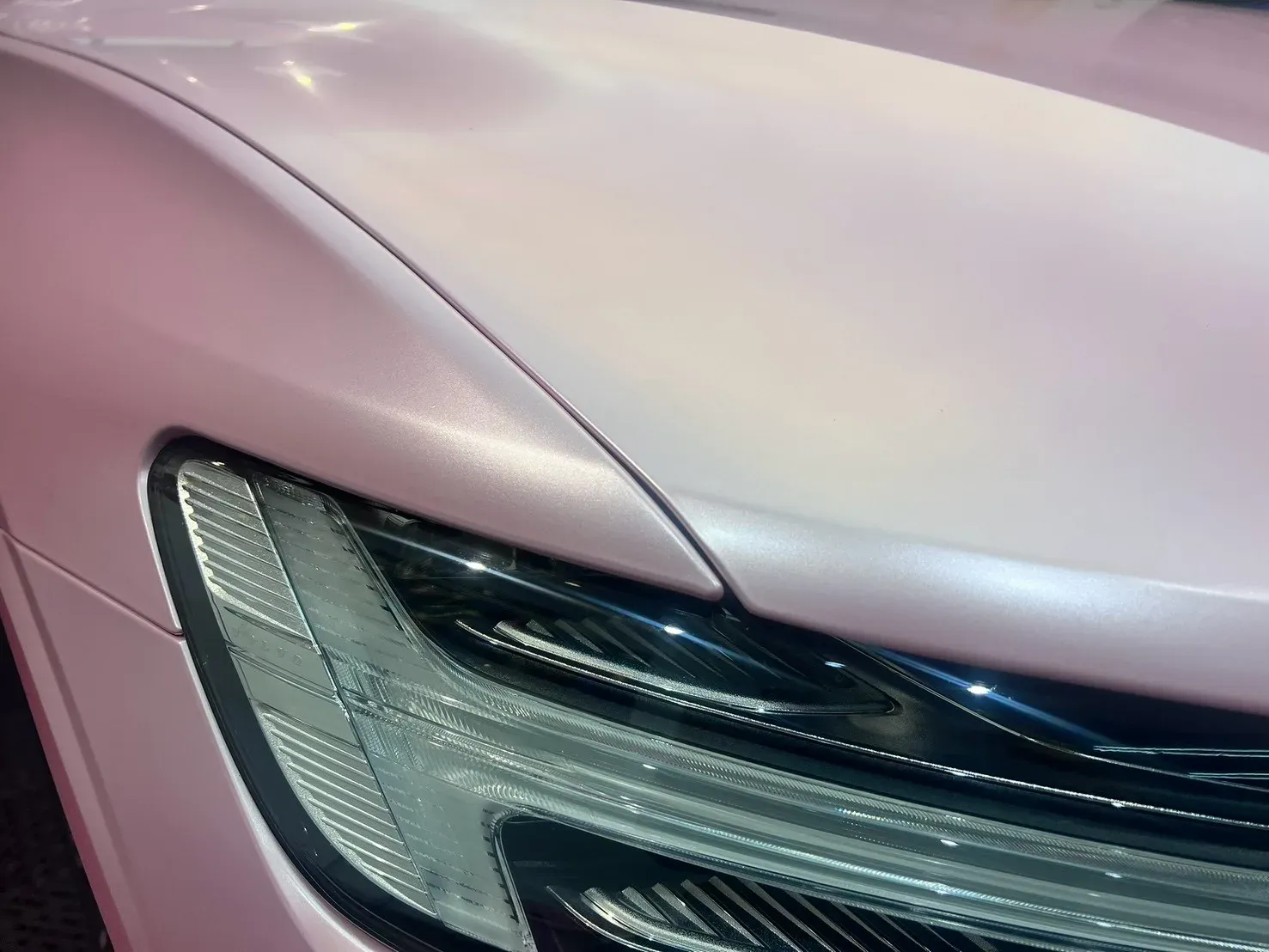 VOLVO V60 電光櫻花粉改色覆膜完工實拍（引擎蓋前緣與頭燈上緣弧線）